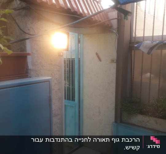 מנורת חוץ דולקת ליד דלת כחולה